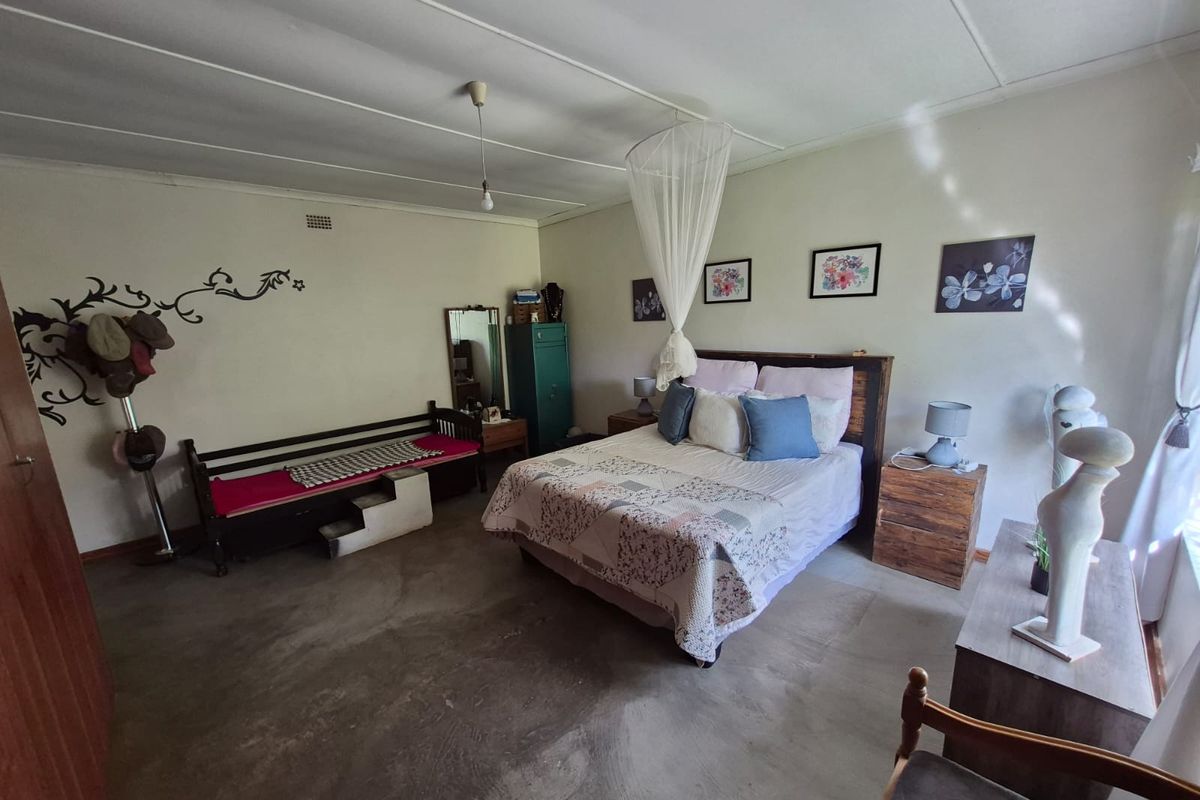 Spacious bedroom featuring exposed concrete flooring, neutral walls, and a simple ceiling design, offering a blank canvas for personalization.