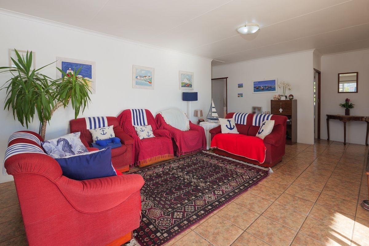 A spacious living room featuring neutral walls, tiled flooring, and coved ceiling details, offering a functional and well-lit area for relaxation.