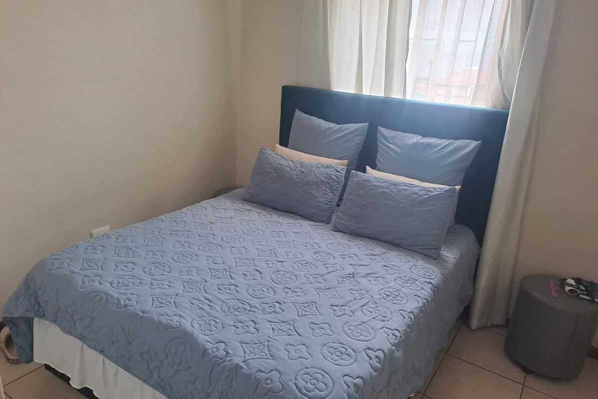 A standard bedroom featuring tiled flooring and window treatments, providing a functional and neutral space ready for personalization.