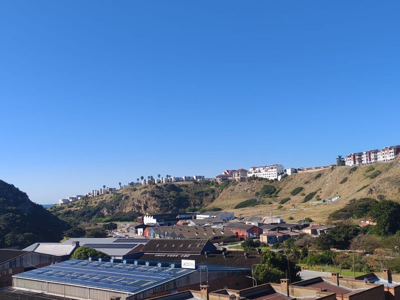 Elevated panoramic view overlooking the surrounding landscape, industrial buildings, and residential properties situated on the hillside.