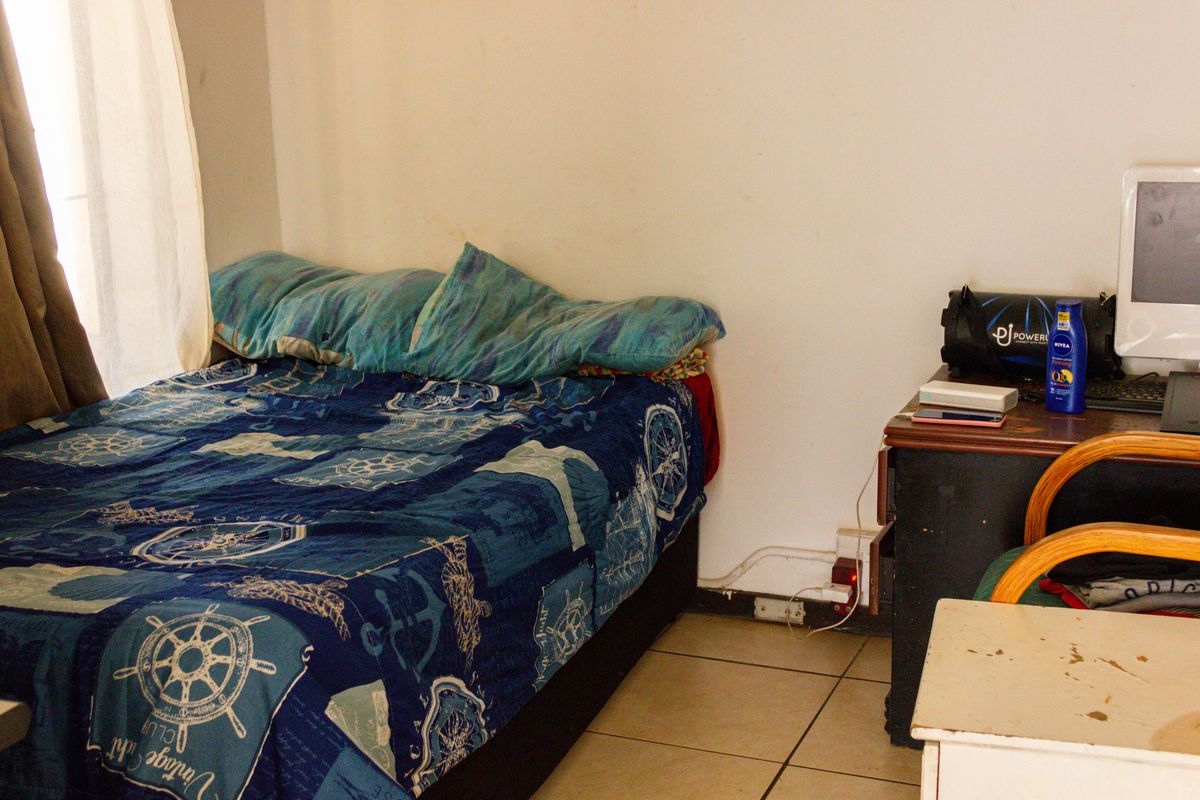 A bedroom featuring tiled flooring and neutral wall finishes, requiring minor cosmetic updates to improve the overall presentation.