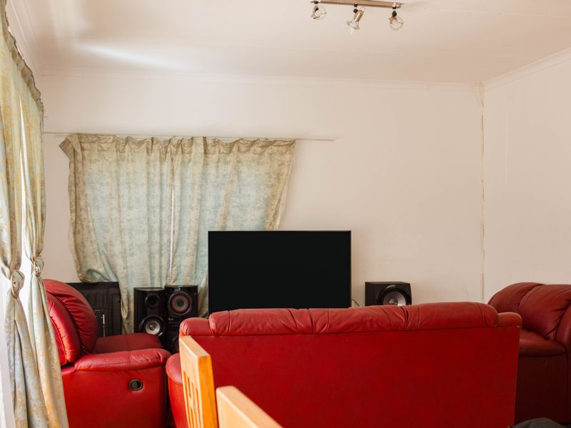 A living room space featuring neutral walls and a ceiling-mounted spotlight track.