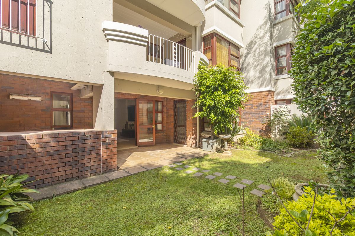 Ground floor apartment featuring a private rear garden, paved patio area, and direct access to the living space through timber framed doors.