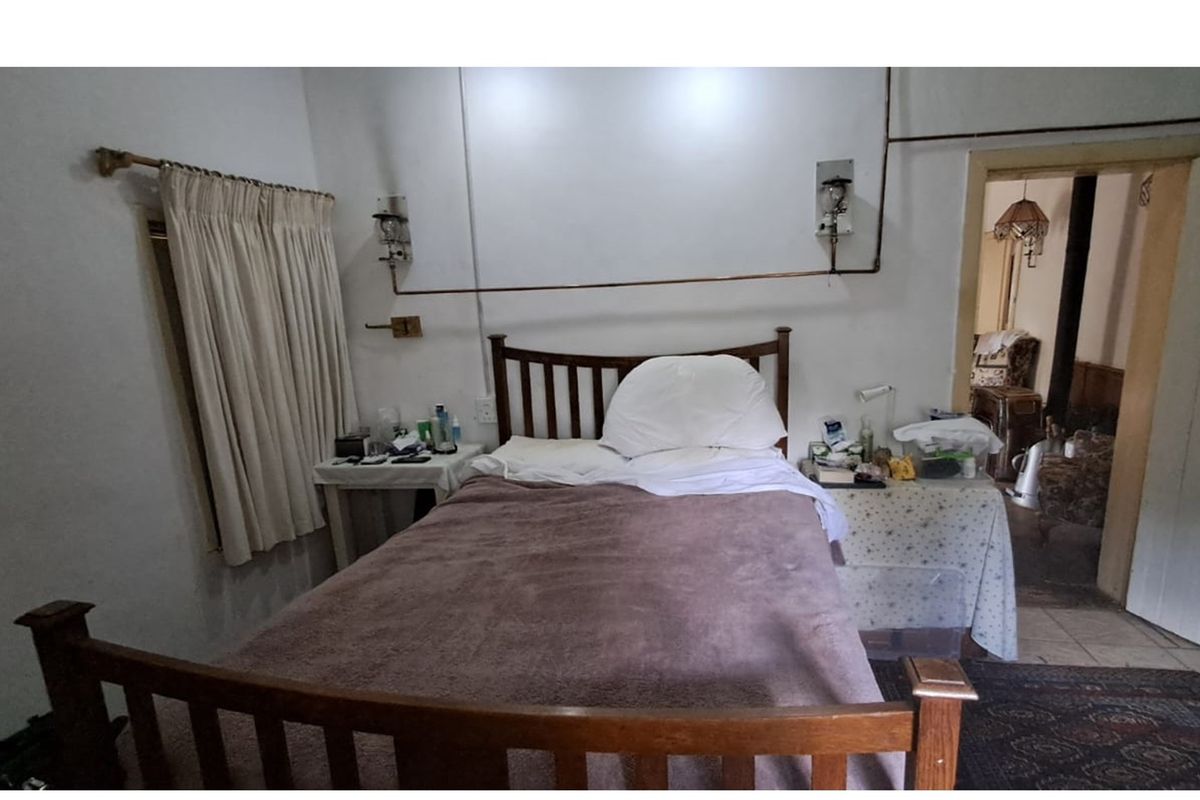 A bedroom featuring exposed surface-mounted electrical conduit and basic finishes, offering a functional space with potential for modernization.