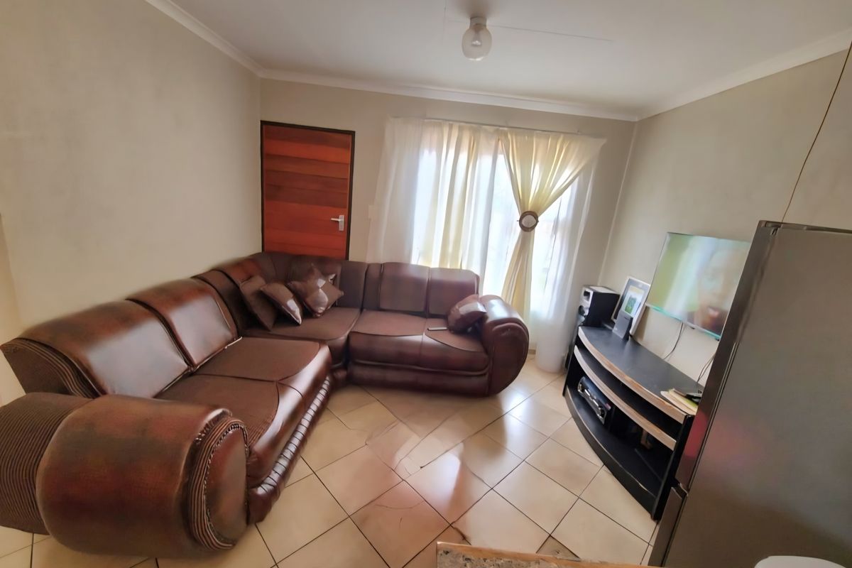 A living room featuring tiled flooring and neutral wall finishes, providing a functional space for relaxation.