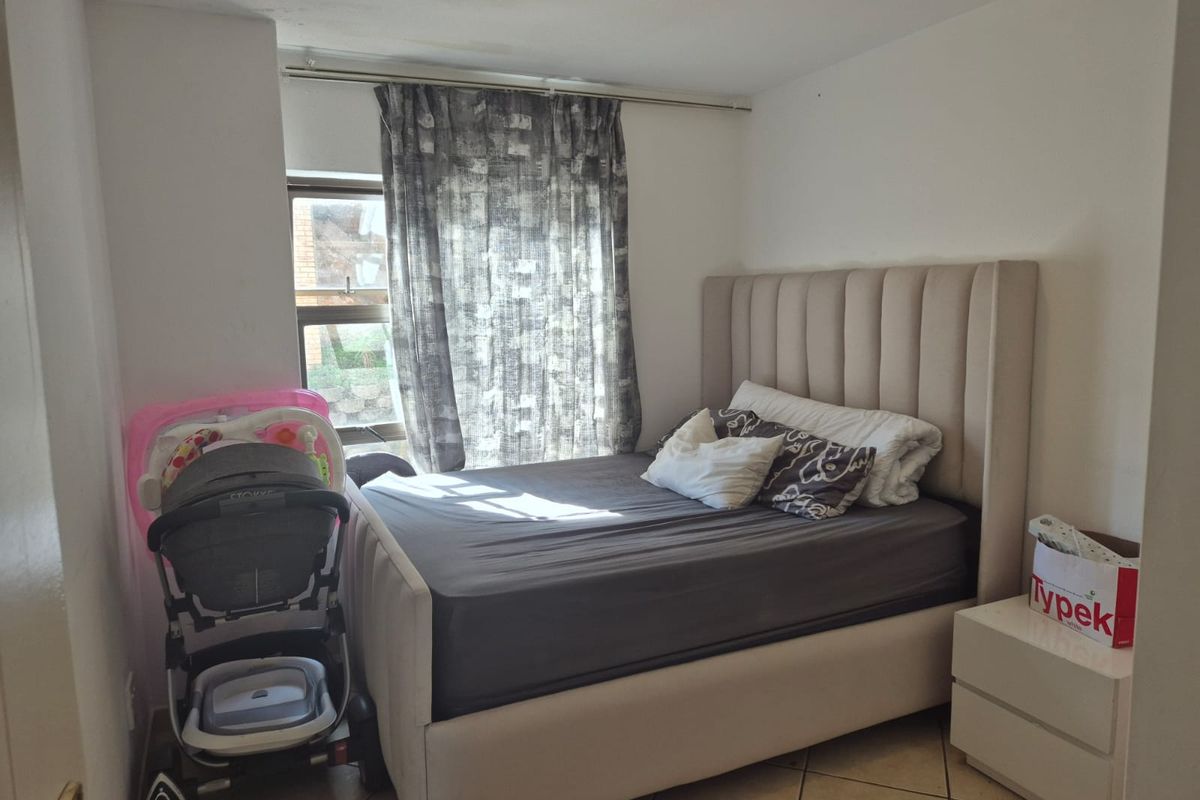 A compact bedroom featuring tiled flooring and a window, providing a functional space with potential for cosmetic updates to enhance its appeal.