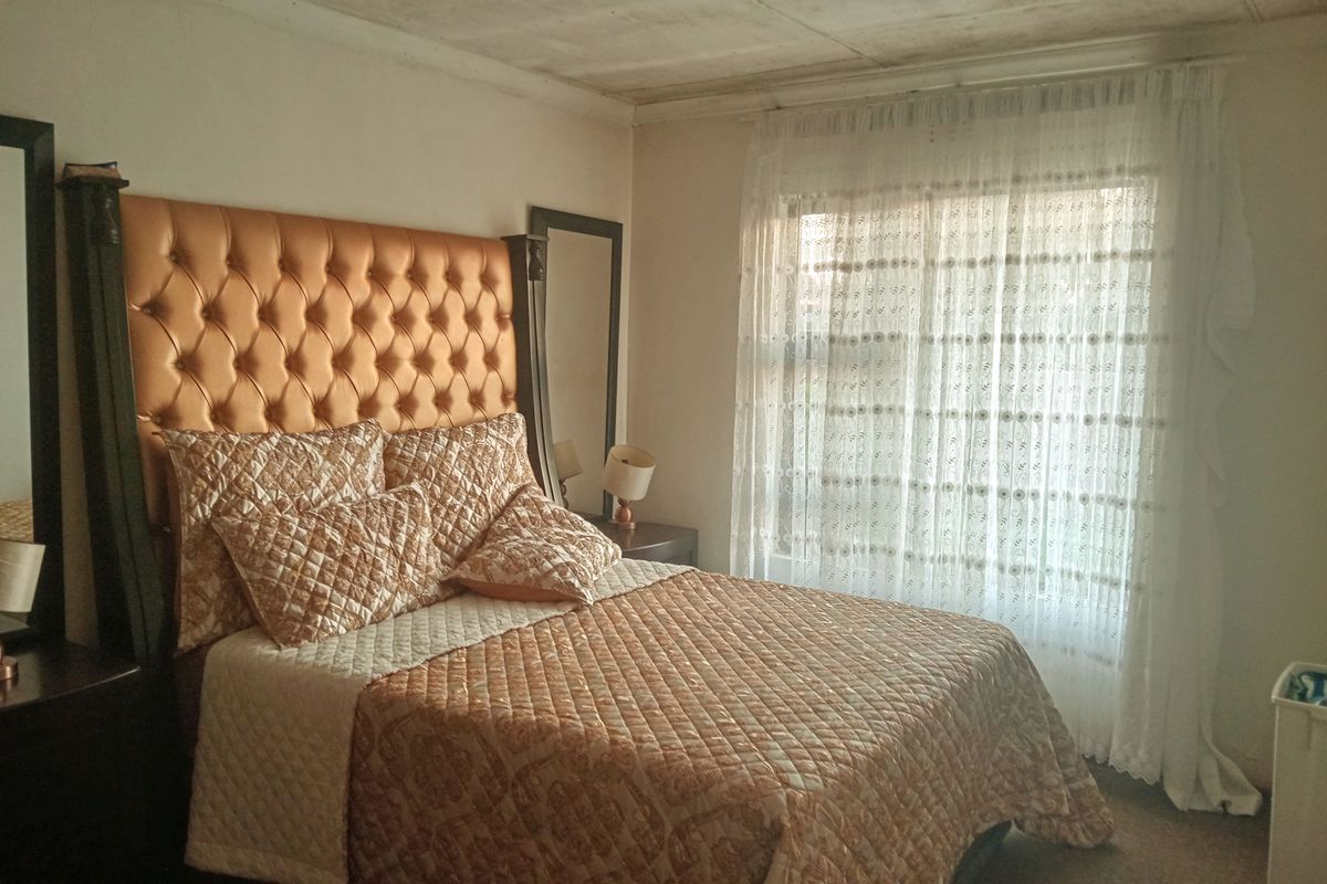 A bedroom featuring a large window with natural light and a textured ceiling finish.