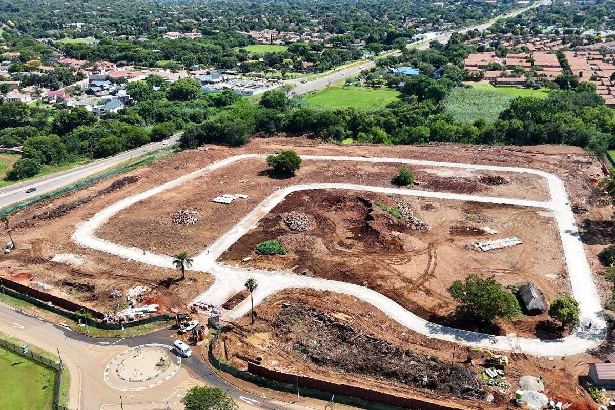 Aerial view of a residential development site showing cleared land, established internal road infrastructure, and surrounding suburban landscape.