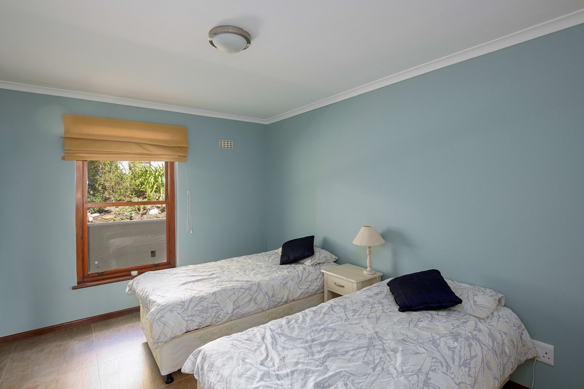 A bedroom featuring tiled flooring, a timber-framed window, and a ceiling-mounted light fixture.