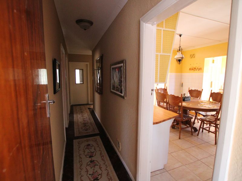 A view from a hallway looking into a dining area, featuring tiled flooring and traditional interior finishes.