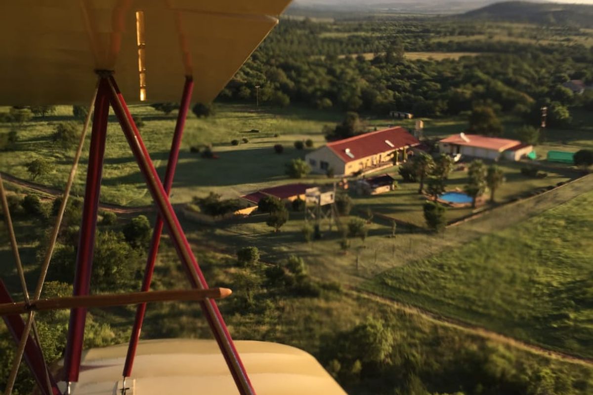 Aerial view of the small holding property featuring the main dwelling, outbuildings, and swimming pool set within a rural landscape.