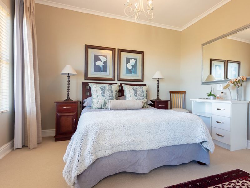A well-maintained bedroom featuring neutral wall tones, carpeted flooring, and classic coving details, providing a comfortable and functional living space.
