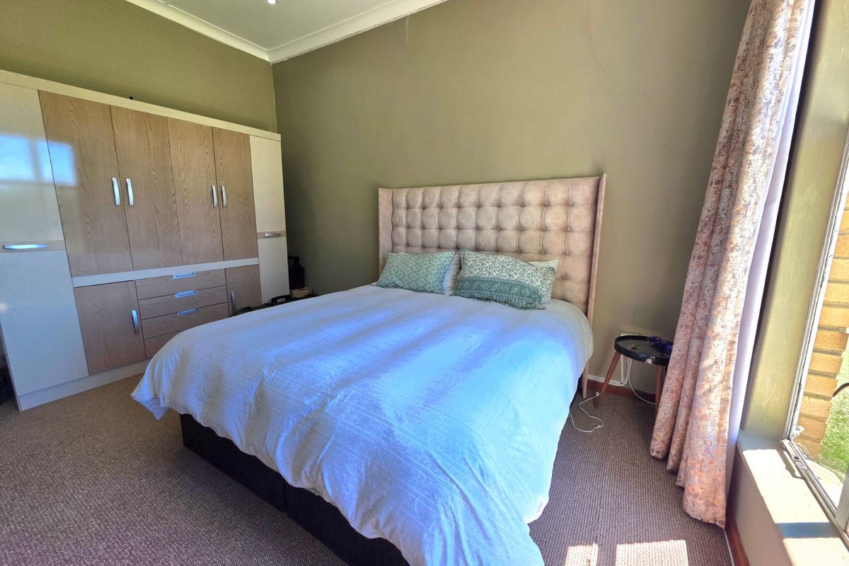 A bedroom featuring built-in cabinetry, carpeted flooring, and recessed lighting, offering a functional space with potential for cosmetic updates.