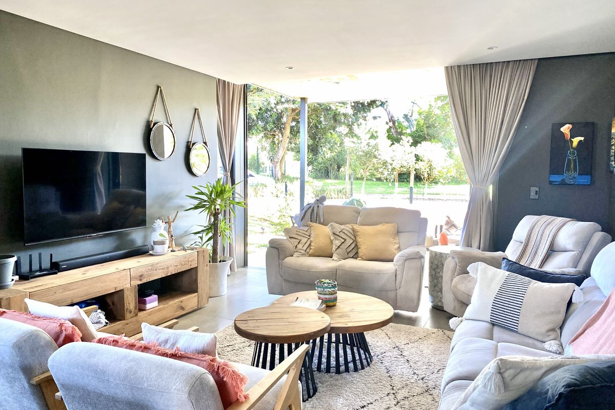 Modern living room featuring large floor-to-ceiling glass sliding doors that provide seamless indoor-outdoor flow and abundant natural light.