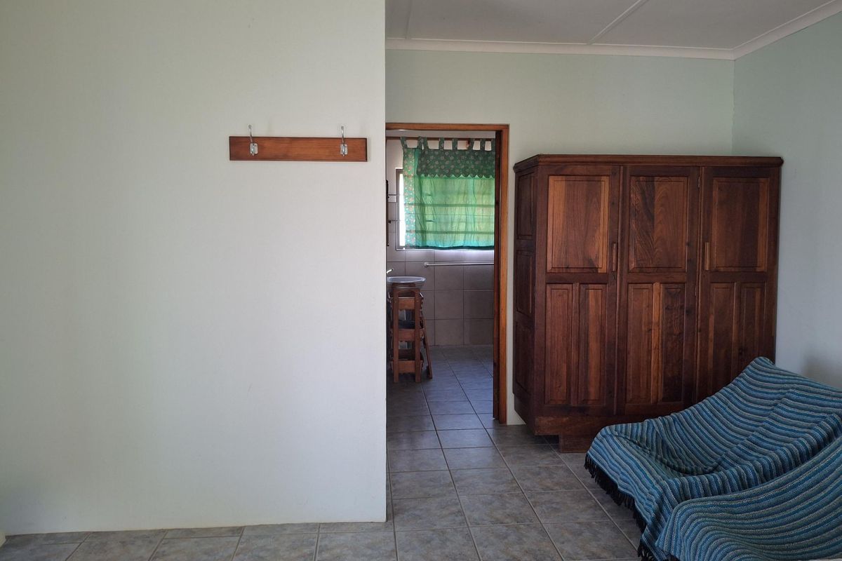 A view from a living area looking through a doorway into a tiled bathroom space with a visible basin.