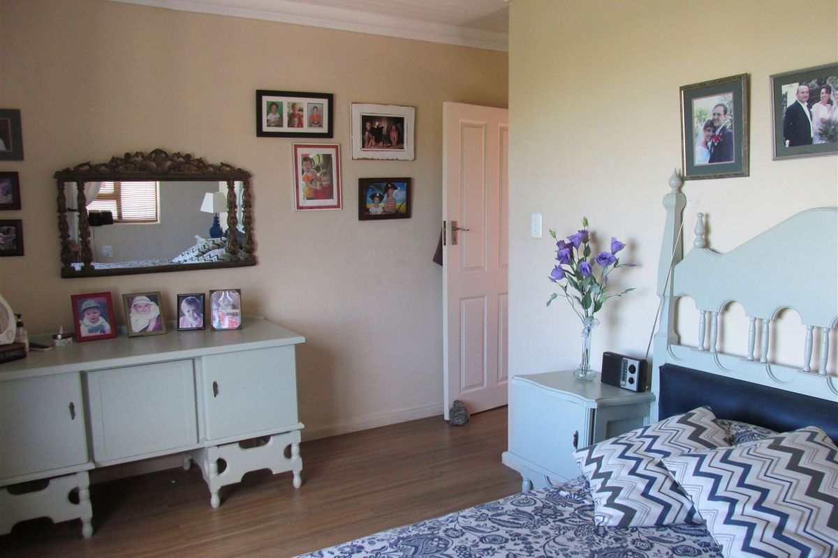 A bedroom featuring laminate flooring and coved ceiling details, providing a functional and neutral space.