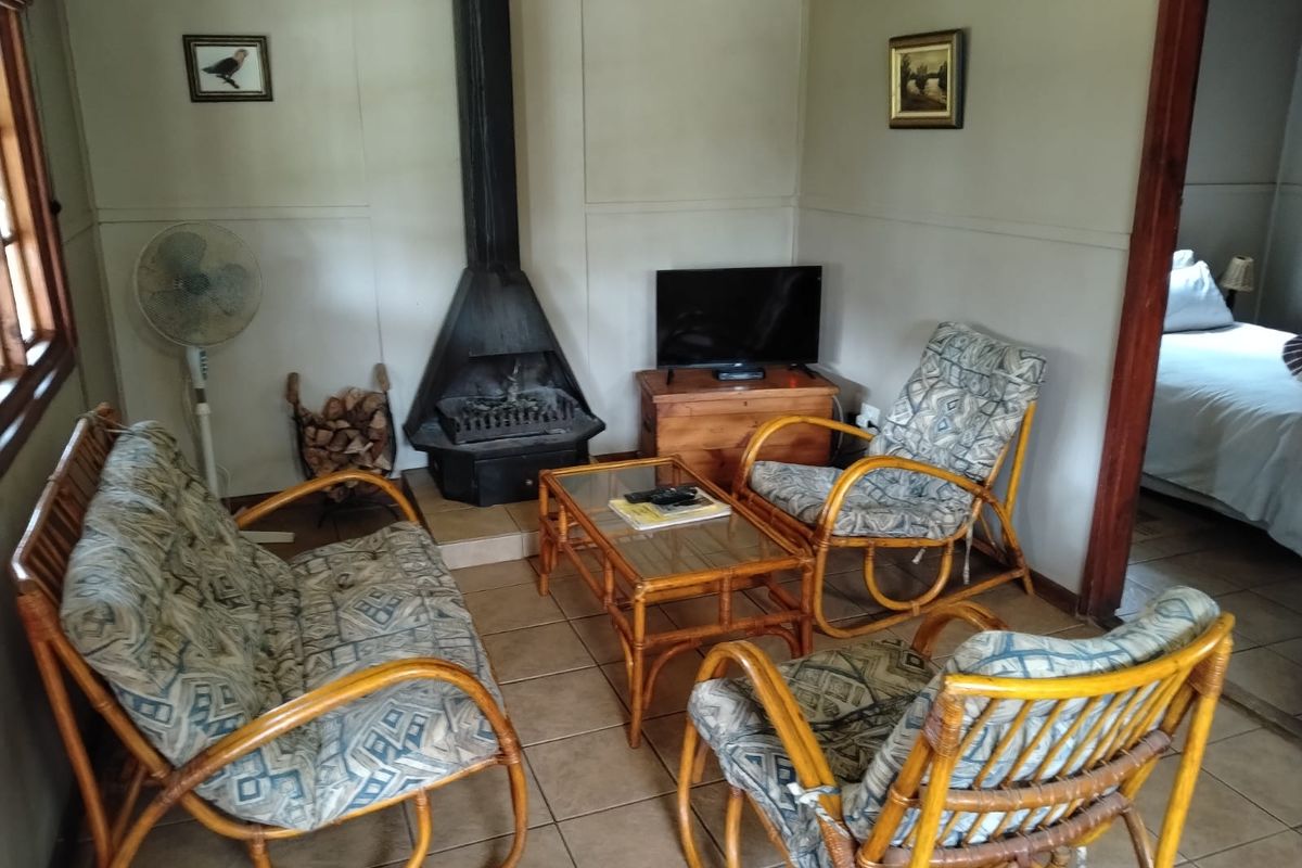 A cozy living room featuring a built-in metal fireplace, tiled flooring, and direct access to an adjacent bedroom.