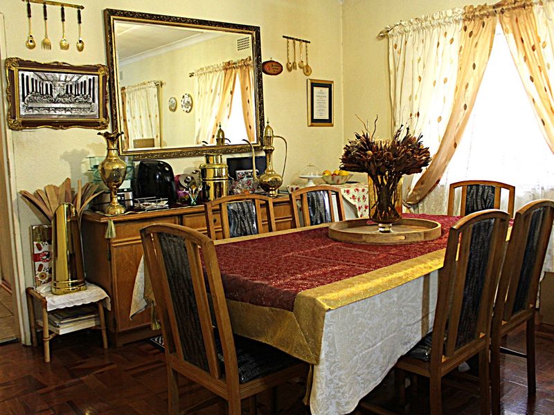 A traditional dining room featuring classic parquet flooring and coved ceiling details, offering a warm and functional space for family meals.