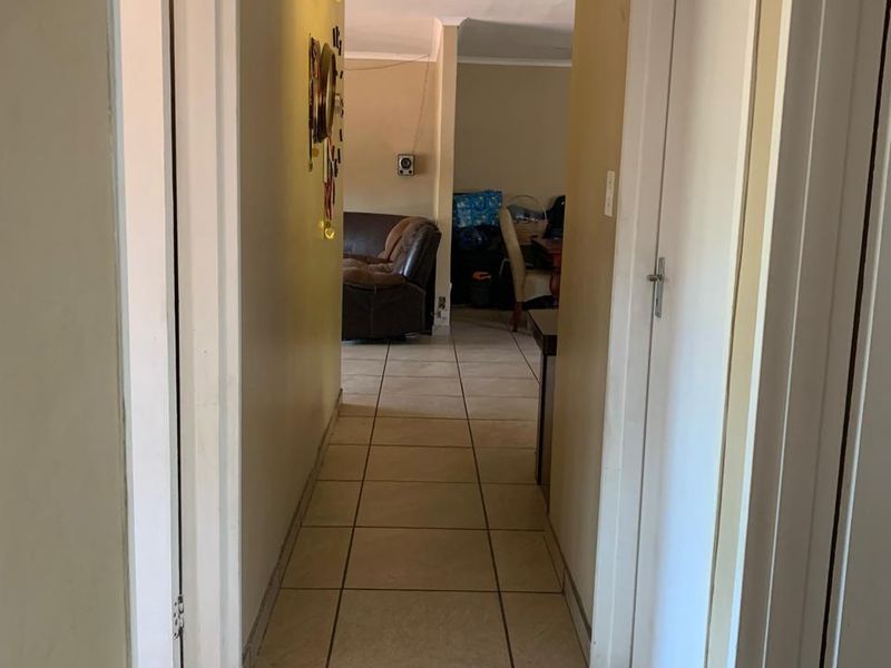 A functional hallway featuring tiled flooring and access to multiple rooms, connecting the living area to the rest of the home.