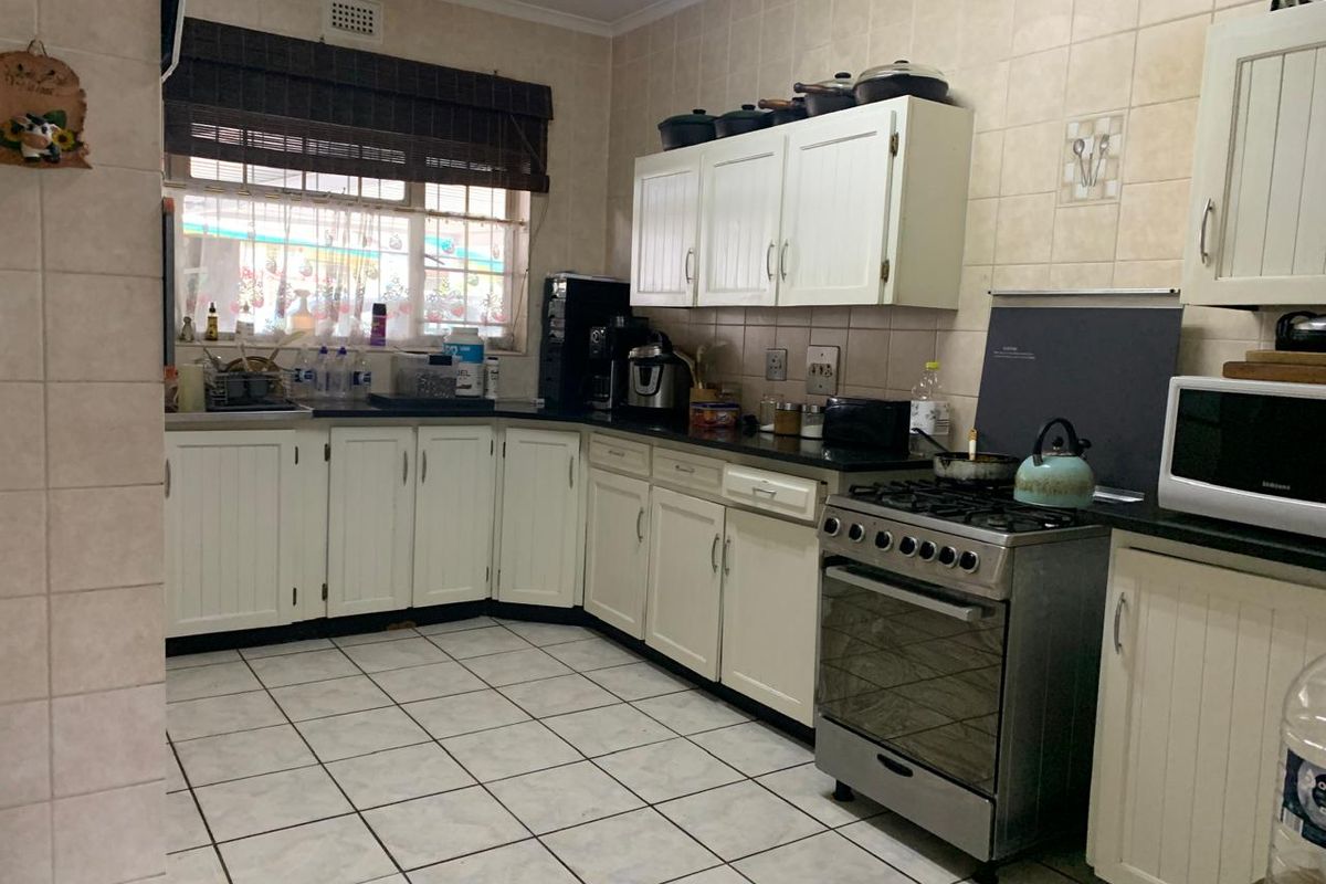 Functional kitchen featuring white cabinetry, tiled flooring, a gas stove, and ample counter space, offering a practical layout for daily meal preparation.
