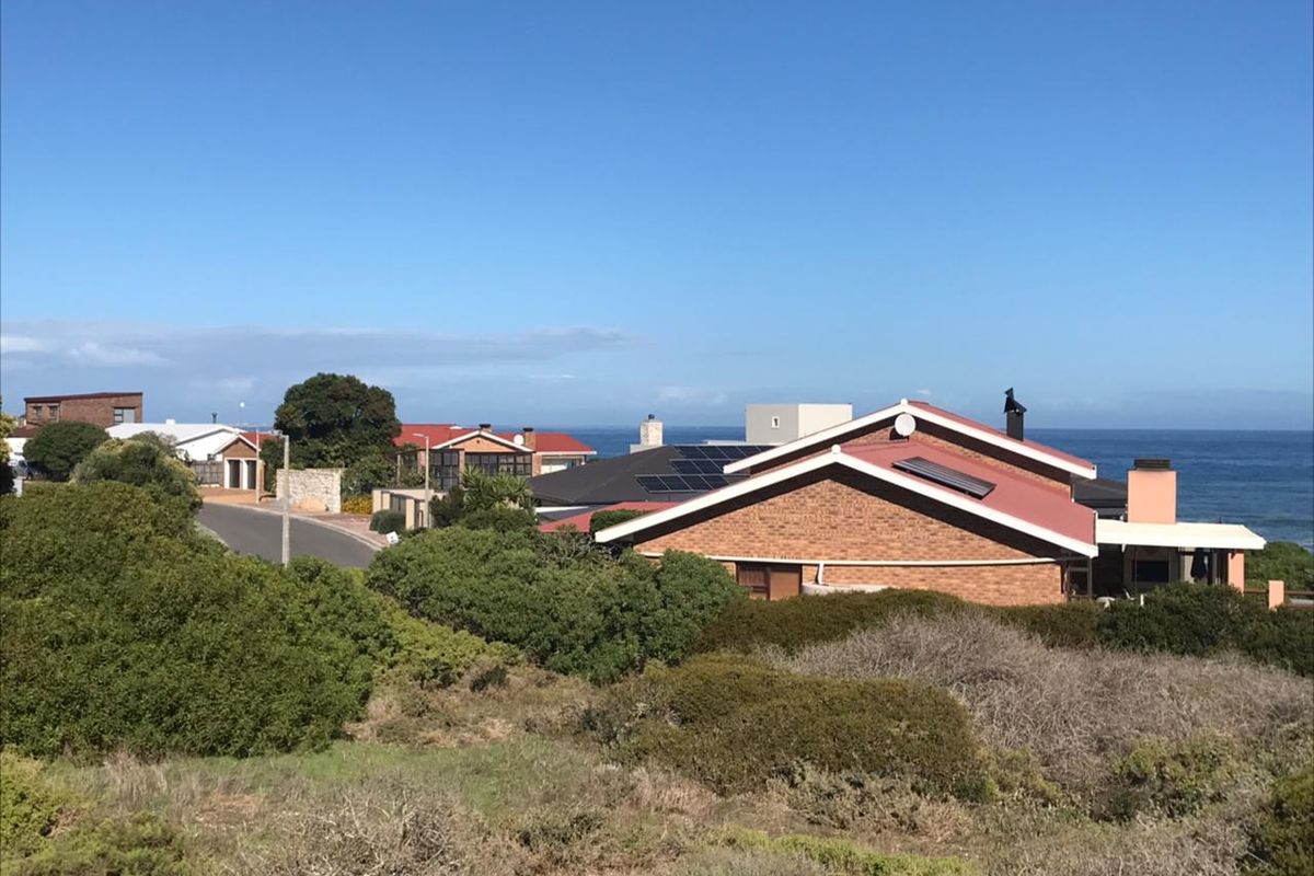 An elevated view of the residential neighborhood and coastal landscape, showcasing the surrounding properties and proximity to the ocean.