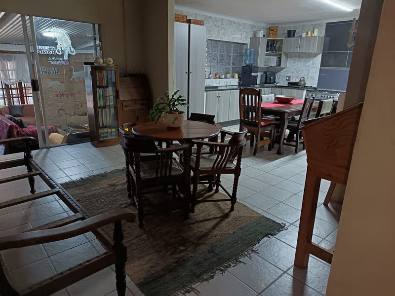 Open-plan living and kitchen area featuring tiled flooring, functional cabinetry, and direct access to an outdoor patio through a sliding glass door.