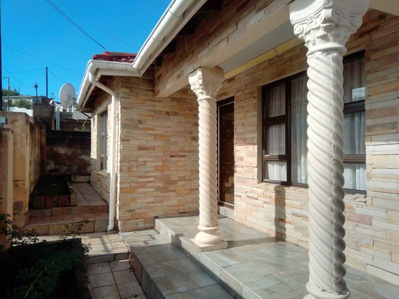 Front facade featuring decorative spiral columns, stone cladding, and a tiled patio entrance area.