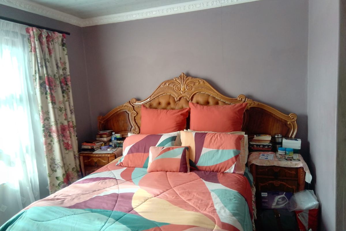 A bedroom featuring decorative ceiling cornicing and neutral wall finishes, providing a functional space for rest.