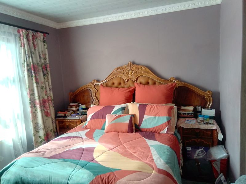A bedroom featuring decorative ceiling cornicing and neutral wall finishes, providing a functional space for rest.