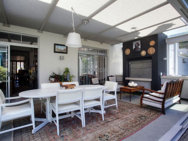 A covered patio area featuring a built-in braai, tiled flooring, and sliding glass doors providing seamless access to the interior living spaces.