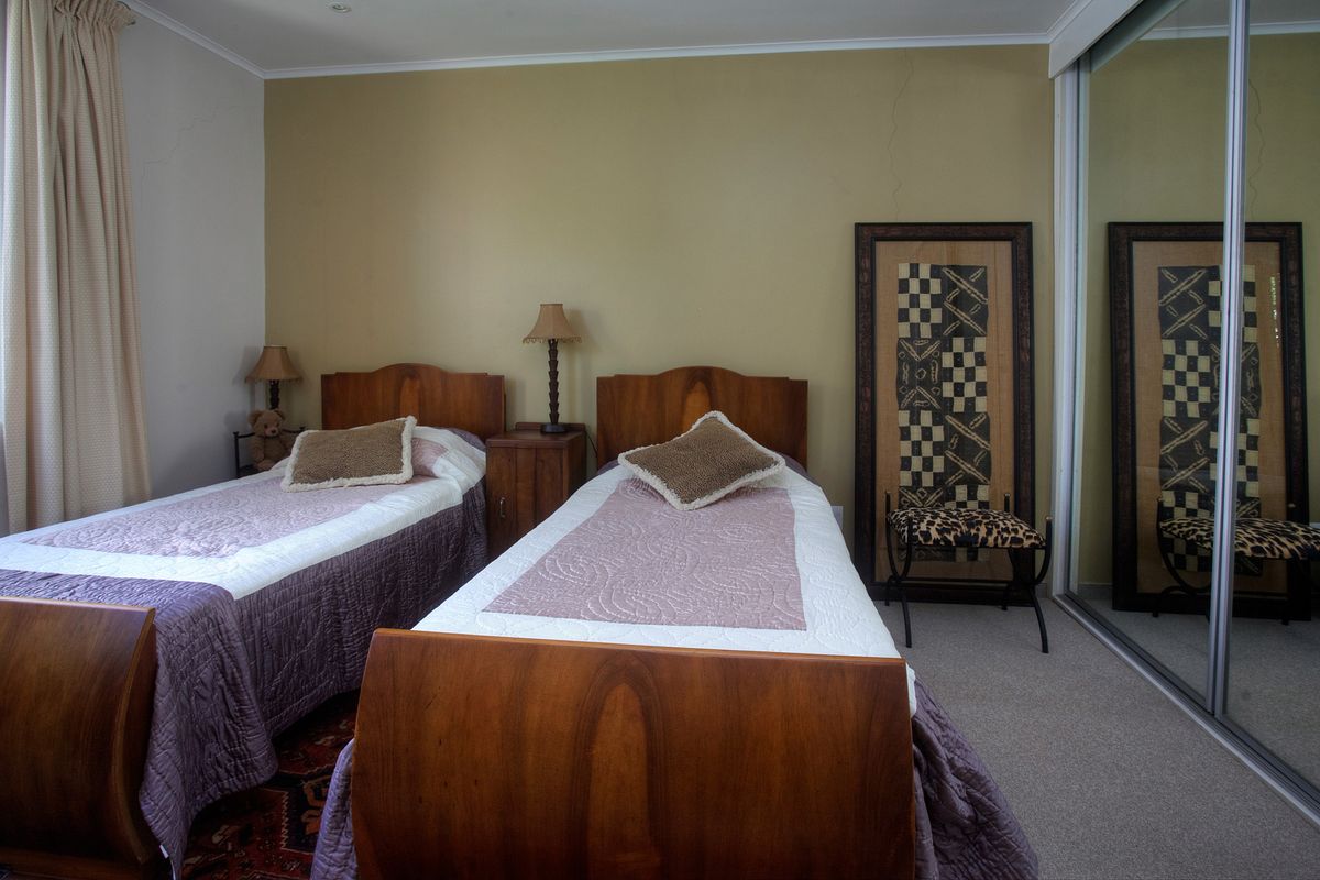 A bedroom featuring carpet flooring, coving, and a built-in sliding door wardrobe with mirrored panels.