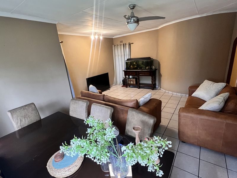 Open plan living and dining area featuring tiled flooring and a ceiling fan, providing a functional space for family gatherings.
