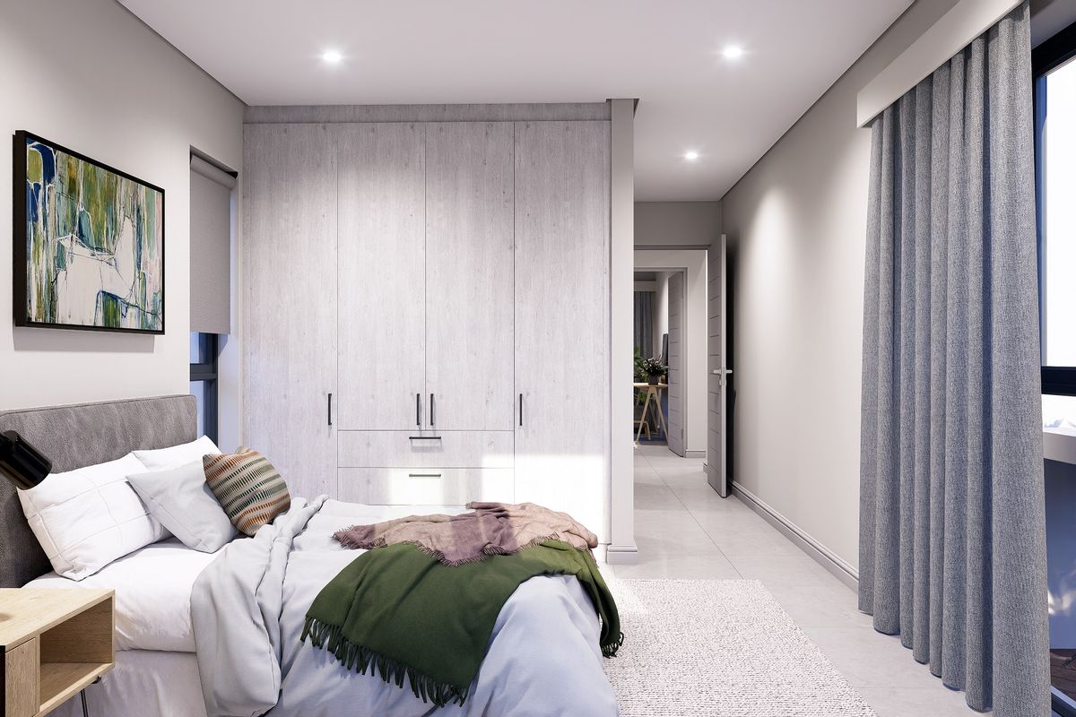 Modern bedroom featuring light-toned built-in cupboards, recessed downlighting, and neutral tiled flooring, creating a clean and contemporary living space.