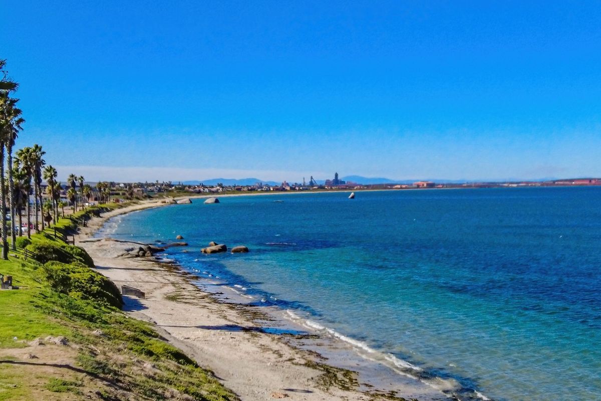 A scenic coastal view overlooking the ocean, sandy beach, and distant shoreline, highlighting the property's prime location.