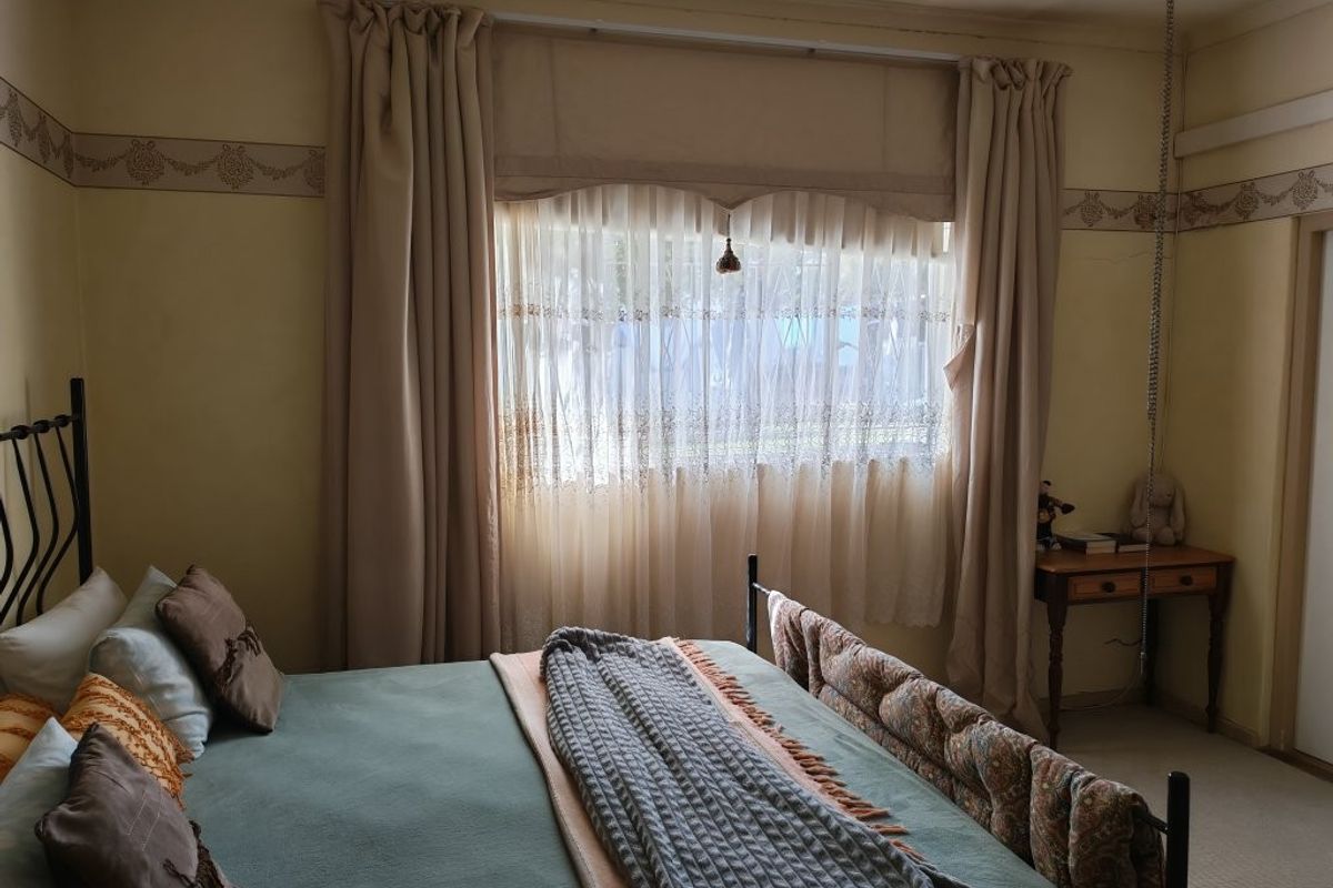 A bedroom featuring carpeted flooring and a decorative wall border, providing a functional and lived-in space.