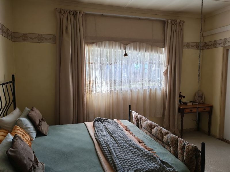 A bedroom featuring carpeted flooring and a decorative wall border, providing a functional and lived-in space.