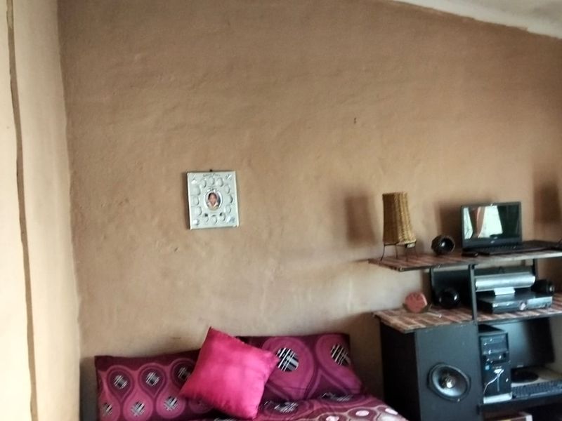 A bedroom featuring textured, unfinished wall surfaces and a basic ceiling finish, requiring cosmetic updates to improve the overall aesthetic.