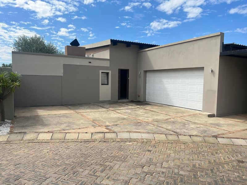 Front elevation of a modern house featuring a single garage, paved driveway, and neutral exterior paint finish.