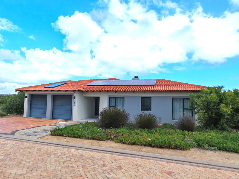 Front elevation of a modern single-story home featuring a double garage, solar energy system, tiled roof, and well-maintained landscaped garden.