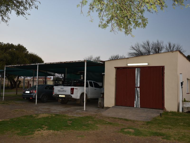 A functional garage with an attached carport structure, providing covered parking space on the property.