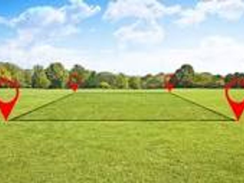 A clear, level residential vacant land plot featuring open green space, ideal for new construction.