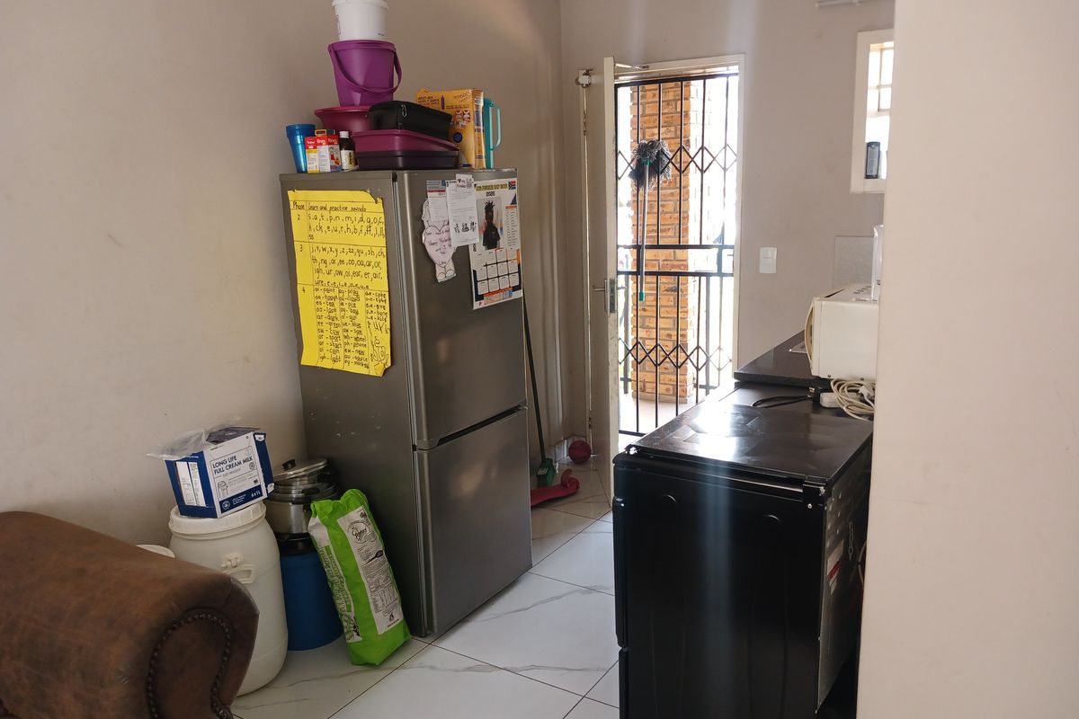 A functional kitchen area featuring tiled flooring and direct access to an exterior security gate.