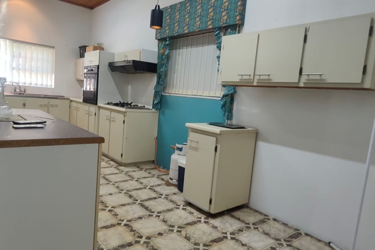 A dated kitchen featuring built-in cabinetry, a gas hob, an integrated oven, and tiled flooring, offering significant potential for a modern renovation.