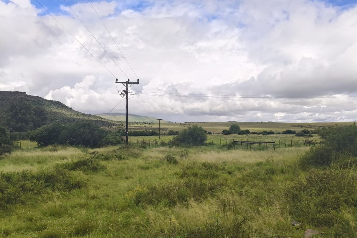 Expansive rural landscape view featuring open grasslands, rolling hills, and existing utility infrastructure on the property.