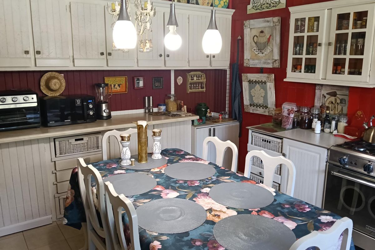 A cozy kitchen featuring white cabinetry, a built-in oven, and a dedicated dining area with a central table.