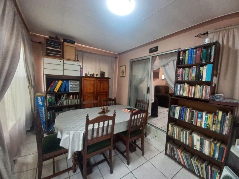 A functional dining room featuring tiled flooring and a sliding glass door providing access to the adjacent living area.