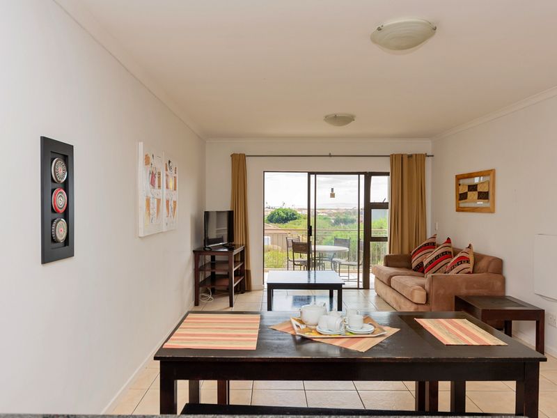 Open plan living area featuring tiled flooring and large sliding glass doors leading to a balcony with scenic views.
