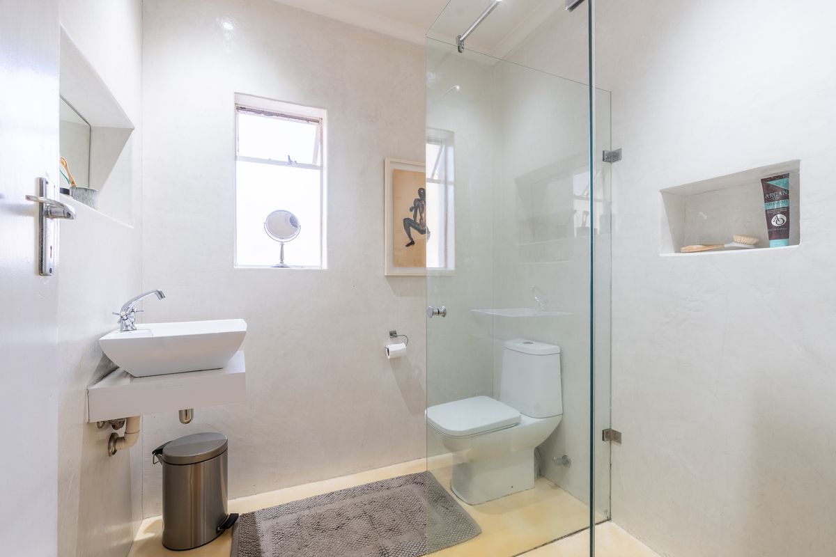Modern bathroom featuring a vessel sink, wall-mounted vanity, and a glass-enclosed shower with a built-in wall niche.