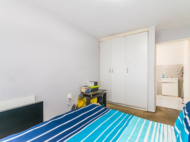 A bedroom featuring a built-in wardrobe and direct access to an en-suite bathroom.