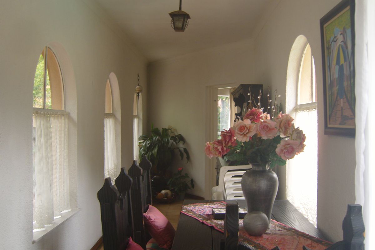 A sunlit living area featuring distinctive arched windows and classic pendant lighting, creating a bright and inviting atmosphere.
